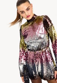 Robe à sequins présentant une silhouette ajustée avec des manches longues. Les couleurs incluent de l'or, du rose, de l'argent et du noir, créant un effet dégradé chatoyant.