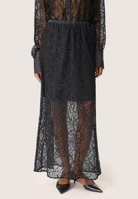 Černá krajková sukně s květinovým vzorem, elastickým pasem a průhledným designem. V kombinaci s špičatými černými podpatky pro elegantní vzhled.