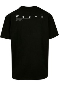 T-shirt noir en coton à manches courtes, arborant le texte "LOST YOUTH" en majuscules au dos et une texture lisse.