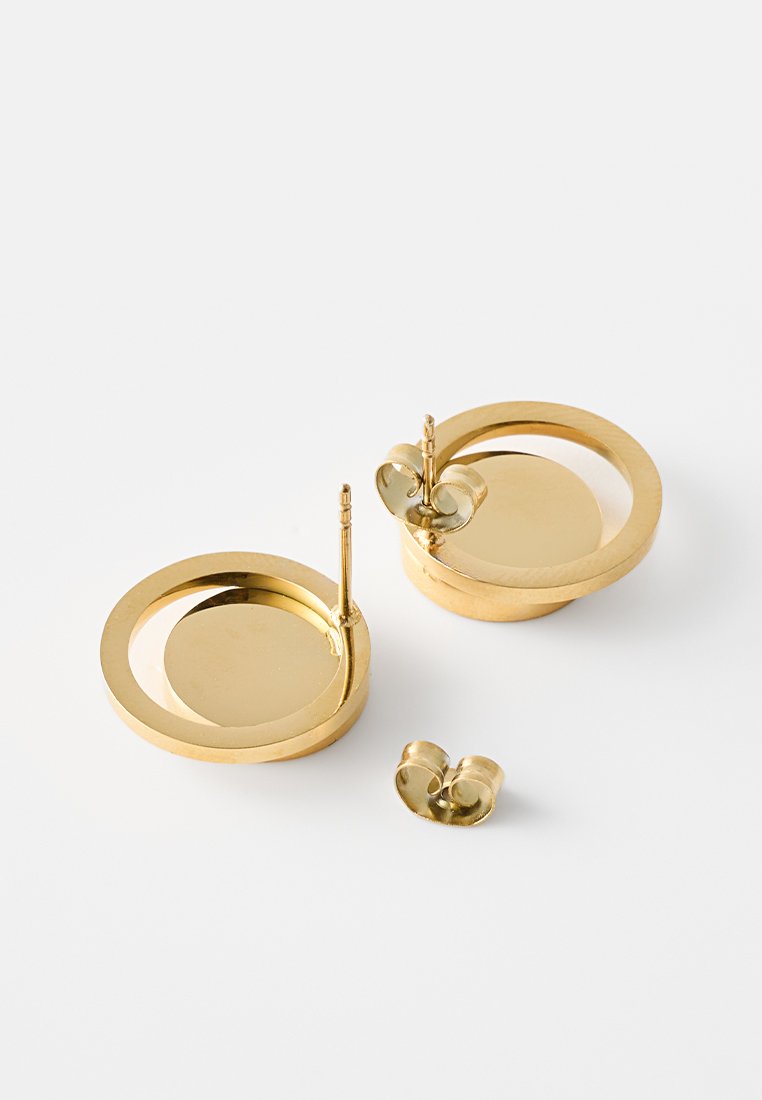 Boucles d'oreilles circulaires en or avec une finition polie, présentant un disque central et une fermeture à poussoir. Texture lisse et design minimaliste.