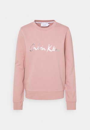 Felpa rosa con colletto girocollo, maniche lunghe, polsini a coste e logo "Calvin Klein" in argento metallizzato sulla parte anteriore. Morbido cotone misto.