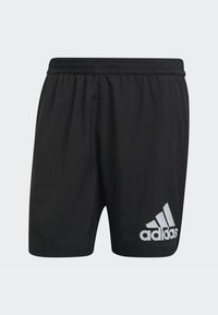 Pantaloni sportivi neri realizzati in tessuto leggero, con vita elastica e un logo Adidas bianco riflettente in basso a sinistra.