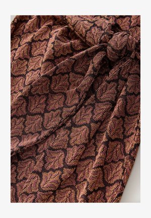 Tekstil s uzorkom lišća u nijansama tamno ružičaste i zlatne, s teksturiranom površinom i crnom pozadinom, formira složen dizajn.