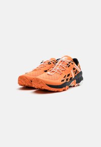 Orange löparskor med en texturerad mesh-överdel, svarta och vita accenter, aggressivt mönster på sulan och reflekterande snören för synlighet.