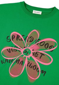 Žalias megztinis su dideliu rožiniu gėlių raštu ir juodu tekstu "PLATINK GERAS NUOTAIKAS", pagamintas iš medvilnės.