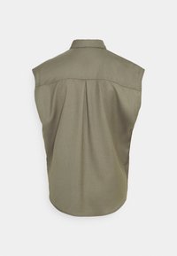 Bez rękawów oliwkowa zielona koszula z plisą z tyłu i kołnierzykiem, wyeksponowana na płasko z tyłu na białym tle.