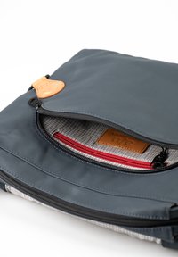 Gray waterproof bag featuring a leather tag, zip closure, and a patterned interior with a red accent zipper. Flat, rectangular design.