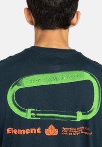 Dark blue t-shirt featuring a large green carabiner graphic on the back, with text "SKATE GO. WORLDWIDE!" and orange "Element" logo.