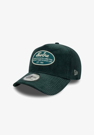 Gorra de pana verde con un logo ovalado bordado, correa ajustable y visera plana con una etiqueta en la parte inferior.