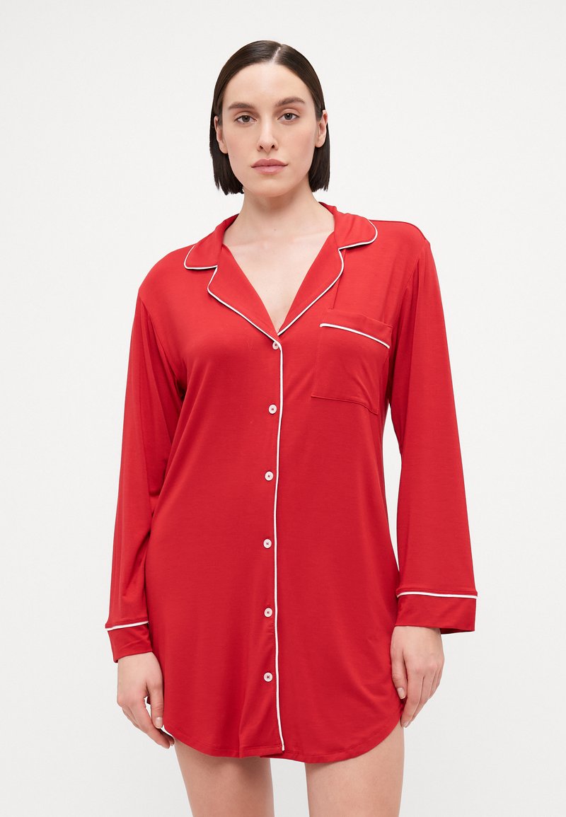 Camisa de noite de manga longa vermelha com detalhes brancos, fecho dianteiro com botões, gola e bolso. Tecido suave, ajuste descontraído, barra curva.