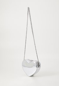 Borsa a forma di cuore argento con finitura lucida, apertura con zip e tracolla a catena. Texture liscia con un design strutturato.