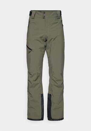Pantalones de esquí verde oliva fabricados con material impermeable, que cuentan con un cierre de doble botón, bolsillos con cremallera en los laterales y acentos negros en la parte inferior de las piernas.