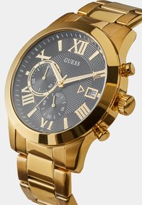 Montre en acier inoxydable doré avec un cadran noir texturé, des index en chiffres romains et trois sous-cadrans. Comprend un guichet de date et des poussoirs.