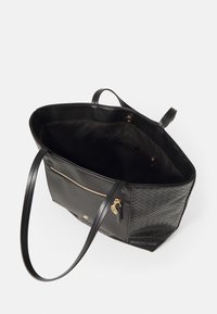 Czarna torba typu tote o plecionej fakturze i gładkich skórzanych panelach. Posiada złote okucia, kieszeń na zamek oraz podwójne uchwyty. Wnętrze jest wyłożone podszewką.