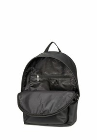 Mochila negra hecha de tela suave. Forma redondeada con un bolsillo delantero con cremallera y un compartimento interior, forrado con material con patrón de logotipos.