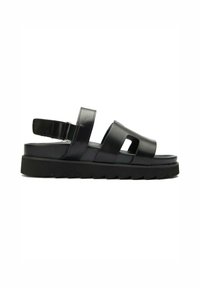Black leather sandal with two wide straps, open toe, and adjustable heel strap. Features a thick, textured black sole for grip.