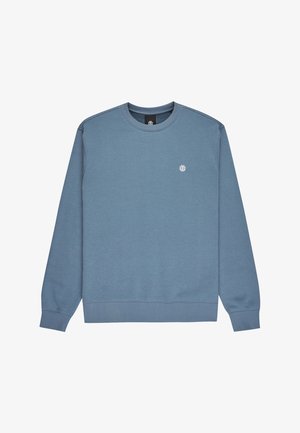 Yhdenmukainen sininen pyöreäkauluksinen collegepaita, jossa on ribbikuvioidut hihansuut ja helma, ja vasemmassa rinnassa pieni valkoinen ympyrälogo.