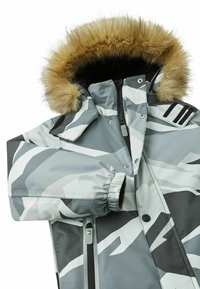 Szara camo pikowana kurtka z kapturem wykończonym sztucznym futrem, elastycznymi mankietami i zamkiem błyskawicznym z przodu. Wysoki kołnierz i kontrastujące czarne detale hardware'u.