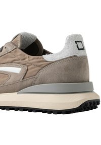 Baskets en suedé marron avec des accents gris, un col de talon texturé et une bande latérale blanche. Elles présentent une semelle intermédiaire épaisse de couleur crème et une semelle extérieure noire.