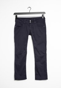 Tmavě modré bavlněné kalhoty s rovnými nohavicemi, se dvěma předními kapsami a zapínáním na knoflík. Visí na černém plastovém ramínku.