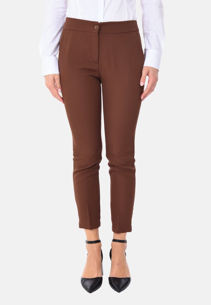 Pantaloni marroni su misura con una texture liscia, dotati di chiusura frontale con bottone, vestibilità slim e lunghezza alla caviglia, abbinati a tacchi neri.