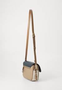 Crossbody-väska i texturerad läder i beige, krämfärgad och marinblå. Har en justerbar rem och detaljer i guld. Kompakt rektangulär form.