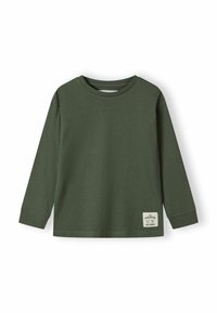 Maglietta a maniche lunghe verde scuro con colletto girocollo, polsini a coste e una piccola etichetta rettangolare bianca sul lato sinistro in basso.