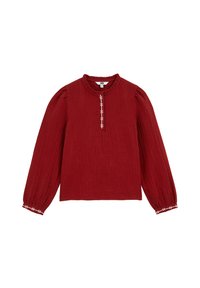 Blusa bordeaux con finitura testurizzata, collo rotondo con volant e maniche lunghe. Presenta accenti bianchi ricamati lungo la parte anteriore e ai polsini.