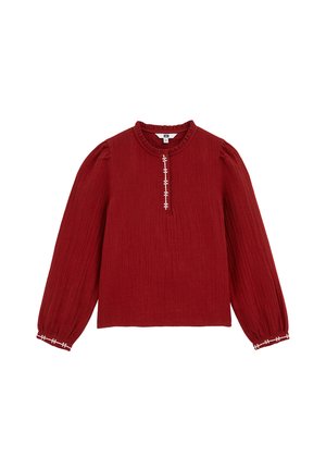 Blusa bordeaux con finitura testurizzata, collo rotondo con volant e maniche lunghe. Presenta accenti bianchi ricamati lungo la parte anteriore e ai polsini.
