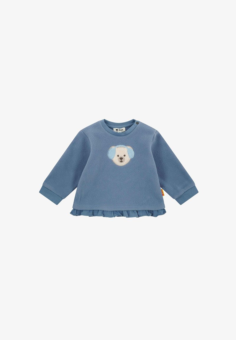 Sweatshirt en polaire bleue à manches longues, présentant une application en forme de tête de chien à l'avant, un ourlet à volants et des fermetures à pression sur les épaules pour un enfilage facile.