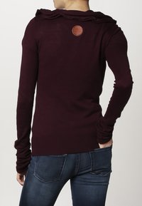 Bordowy sweter z długim rękawem i kapturem, wykonany z teksturowanej tkaniny, z prążkowanym wykończeniem i skórzaną naszywką z logo z tyłu. Dopasowany krój z otworami na kciuki.