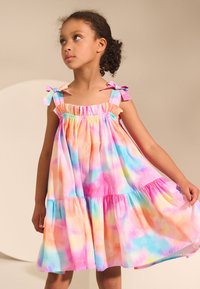 Vestido de varias capas y colores, confeccionado con tela ligera, que presenta tonos pastel de rosa, azul y amarillo, con lazos en los hombros.