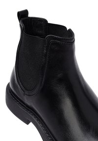 Stivale Chelsea in pelle nera con pannello elastico laterale e linguetta, dotato di tacco basso e finitura liscia.