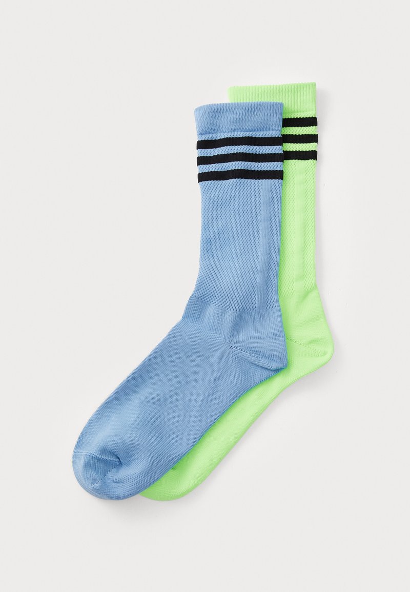 Modri in neon zeleni nogavice z črnimi črtami, izdelane iz mrežastega materiala, z teksturiranim vzorcem in dolžino do gležnjev.