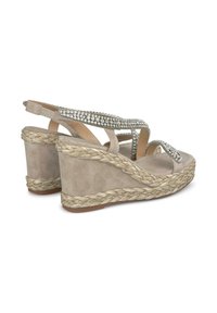 Sandali con zeppa beige con una finitura in suede testurizzato, base in juta intrecciata e una fascia di strass luccicanti sopra il piede.