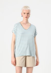 Lyseblå stribet t-shirt med V-hals og opsmøgede korte ærmer, lavet af blødt stof, parret med beige shorts.
