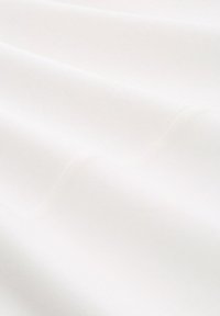 Witte stof met een gladde textuur, met zachte draperingen en een subtiele glans. Het materiaal lijkt lichtgewicht en iets doorschijnend.