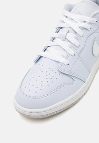 Heledad sinine nahkking, valged paelad, ümmargused perforatsioonid varvaste osas ja valge swoosh'i logo. Sile tekstuur ning kontrastne tall.