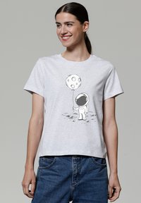 Grijze katoenen t-shirt met korte mouwen, voorzien van een zwart-witte astronaut die een maanpatroon ballon vasthoudt. Casual pasvorm.