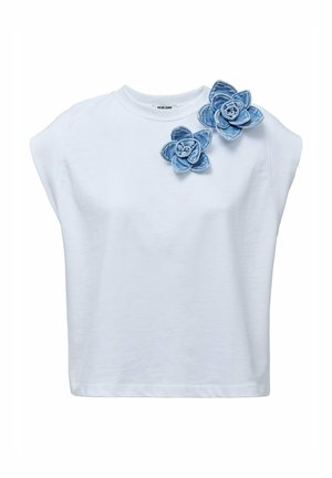 Top blanco sin mangas con escote redondo, que presenta dos aplicaciones de flores de mezclilla en el hombro izquierdo.