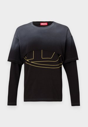 Musta pitkähiha T-paita, jossa on lyhennetty yläosa. Keskellä on keltainen graafinen kuvio ja punainen merkkilabel kauluksessa. Pehmeää puuvillakangasta.