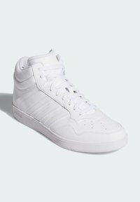 Høj sneakers i helt hvidt læder med teksturerede accenter, perforeret tåboks og flade snørebånd. Har tre parallelle sidelister.