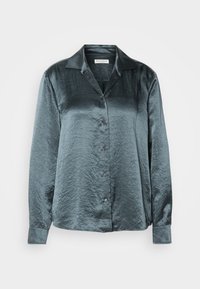 Blouse en satin manches longues boutonnée gris métallisé avec col pointu et manches à poignets, présentée sur fond blanc.