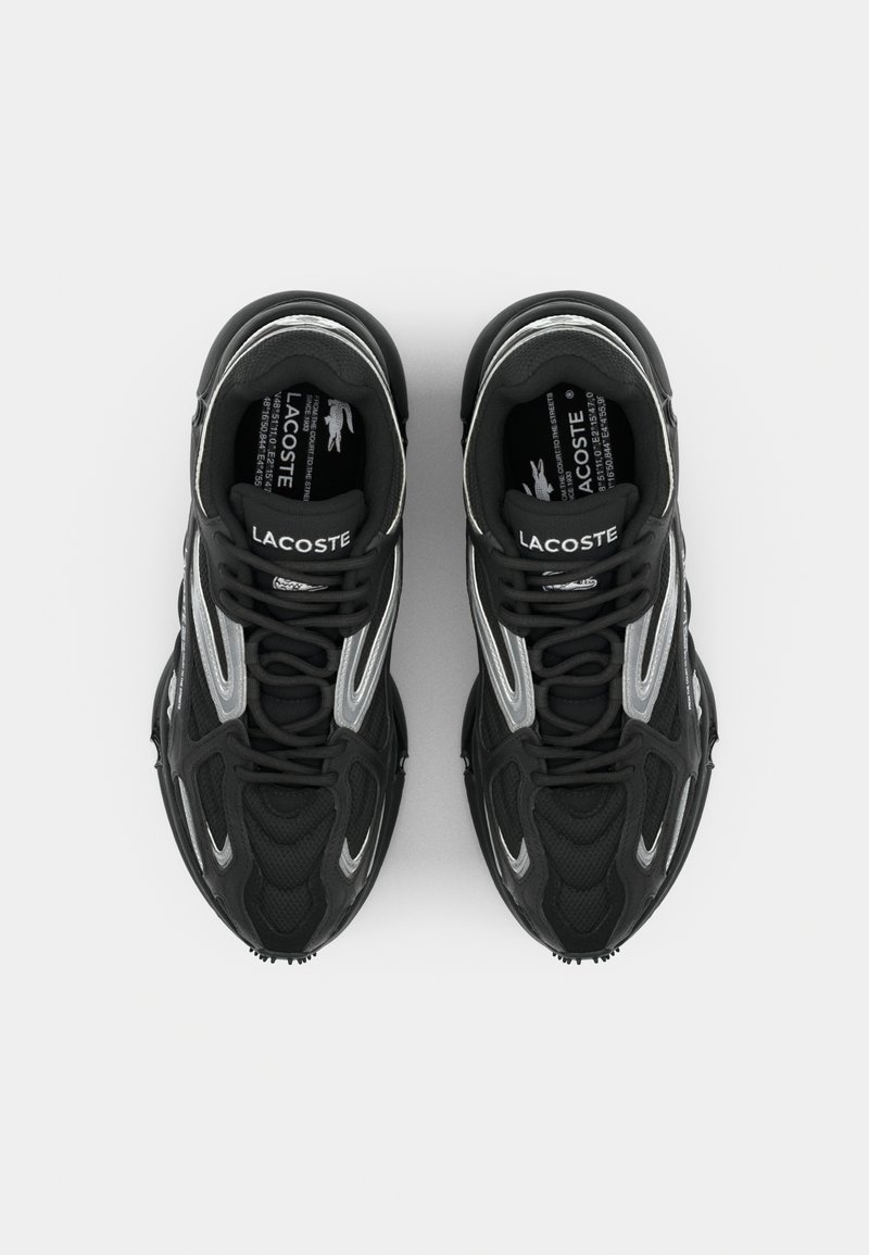 Baskets de sport noires avec tige en mesh et accents argentés, embout renforcé et semelle texturée. Fermeture à lacets avec logo sur la languette.