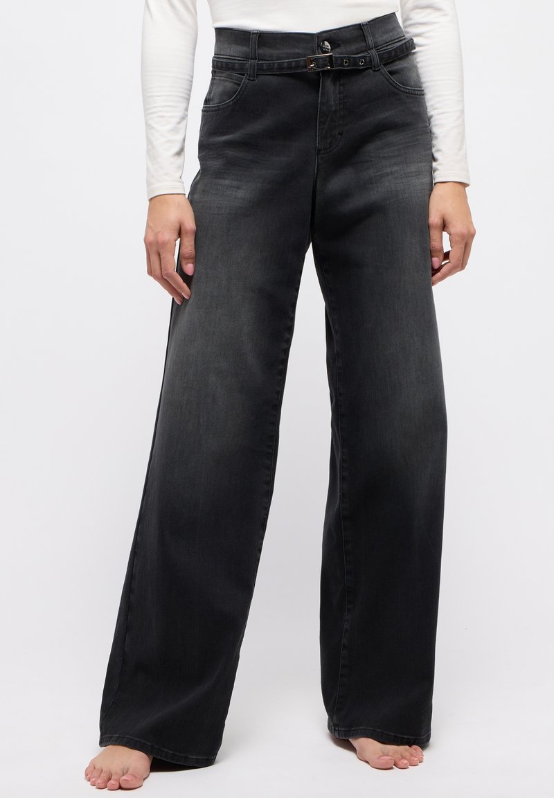 Schwarze, weit geschnittene Jeans aus Denim mit einem hohen Bund und Gürtel, sowie zwei vorderen Taschen. Glatte Textur mit dezenten Ausbleichungen.