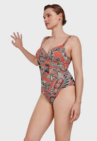 Eén piece badpak met een koraalkleurige basis en zwart bloemenpatroon, verstelbare bandjes, sweetheart halslijn en geplooide details.