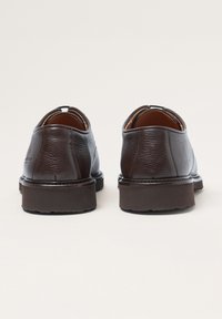 Braune Lederschuhe mit glatter Textur, runder Zehenform und leichtem Absatz. Verfügt über eine hintere Schlaufe für einfaches Anziehen und minimale Nahtdetails.