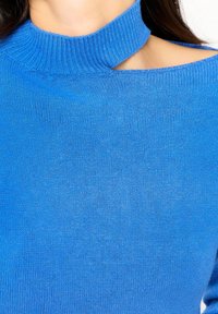 Pull en tricot bleu avec un col montant côtelé et une large découpe aux épaules, présentant une texture lisse et une couleur vive.