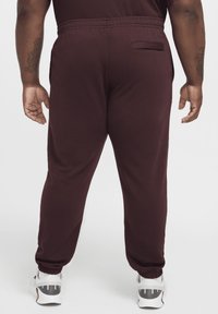 Bourgogne träningsbyxor med elastisk midja, åtsittande muddar och en bakficka. Tillverkade av mjukt, stretchigt tyg.