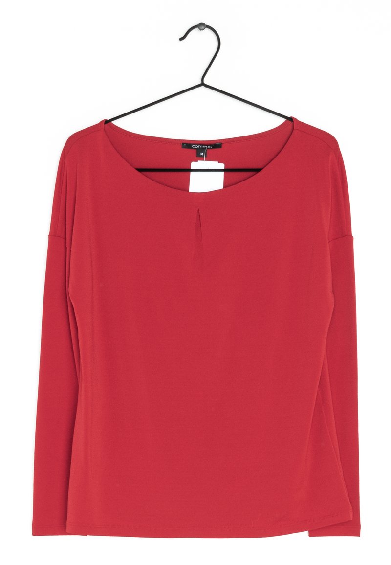 Top rojo de manga larga hecho de una tela suave, con un escote barco y un detalle de pliegue vertical en la parte delantera, colgado en una percha negra.